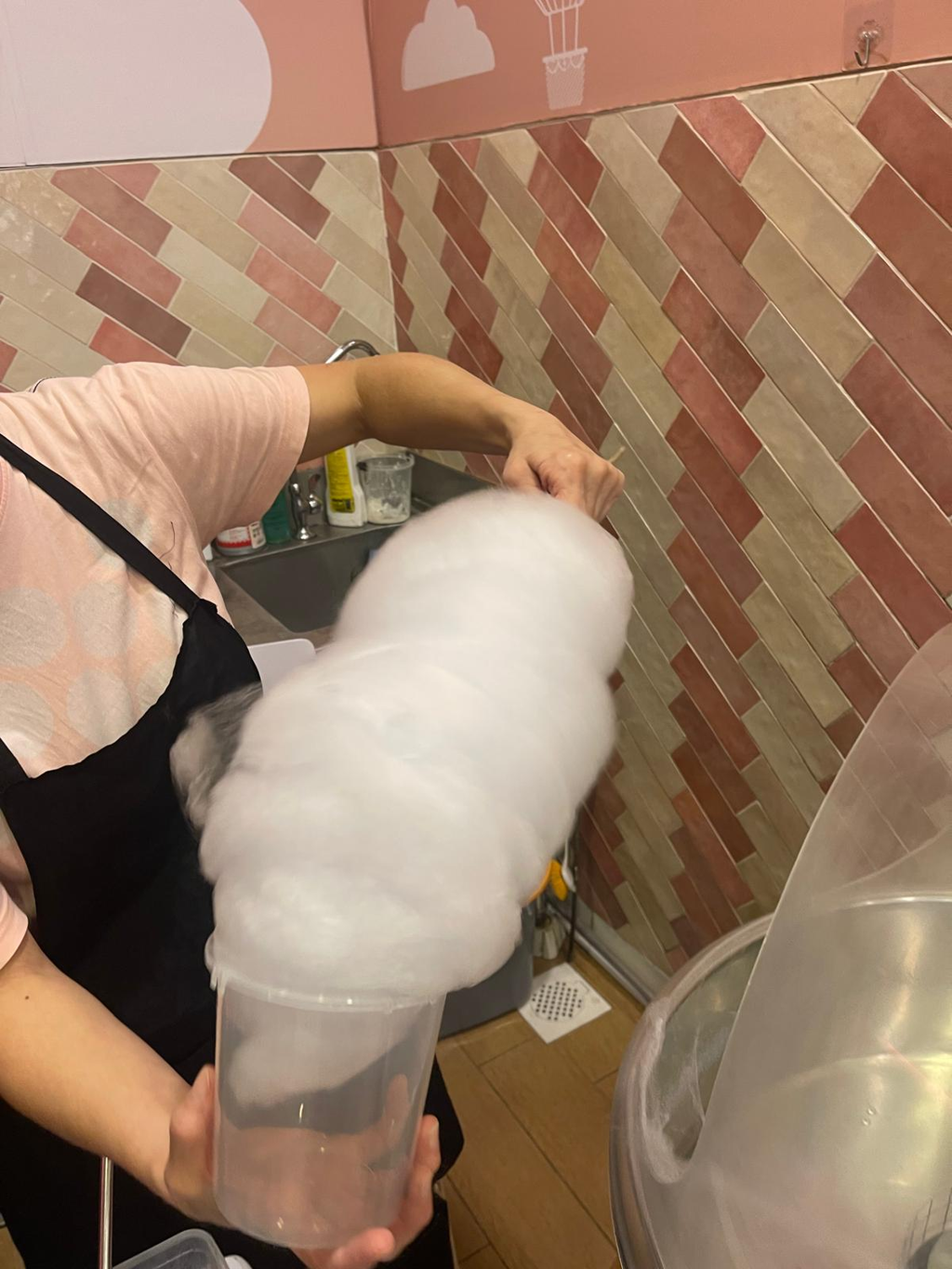 Candy floss being carefully packed into airtight tubs